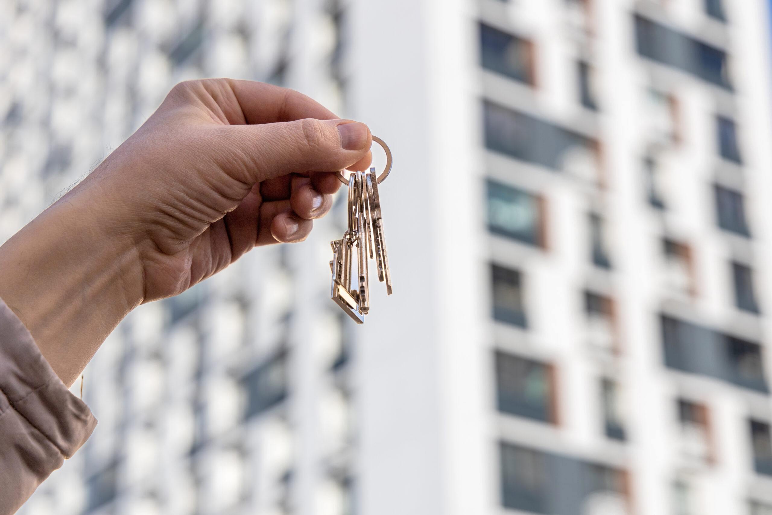 apartment owner holding their keys in front of their apartment
