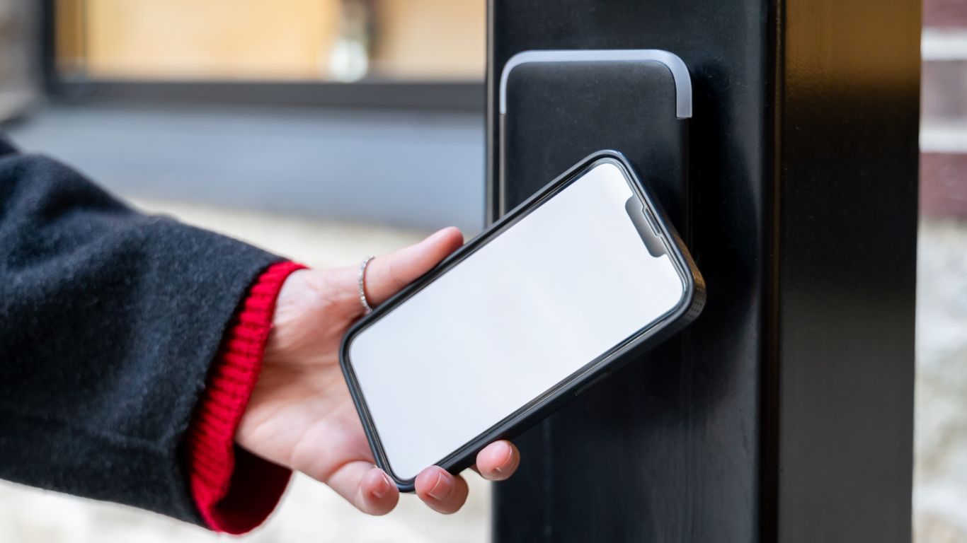 Modern smart lock on a contemporary Melbourne front door, being unlocked with a smartphone