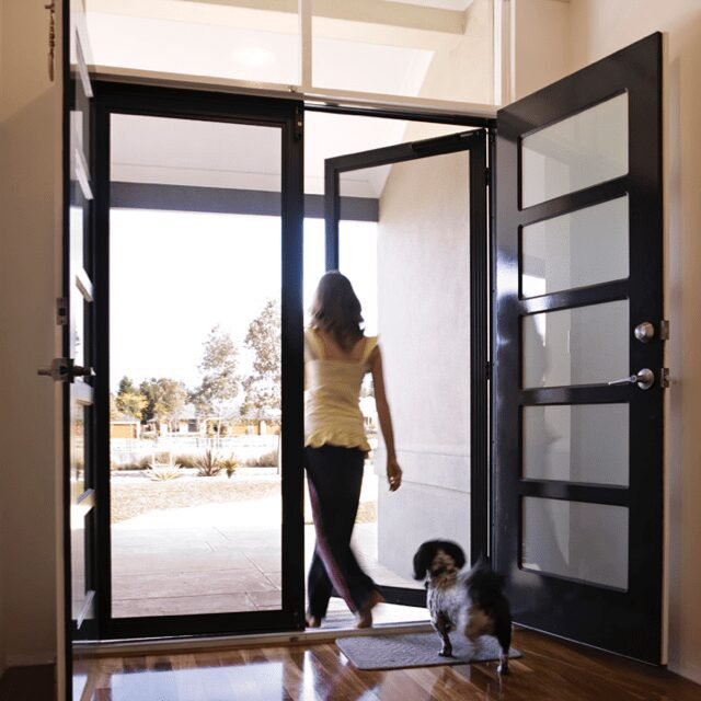 a homeowner walks through their Melbourne front door with a screen